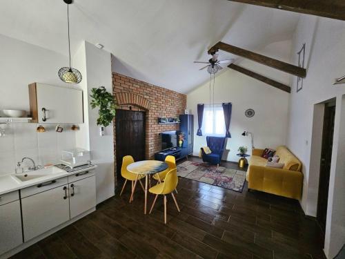 a kitchen and living room with a table and chairs at Marina Cottage in Enying