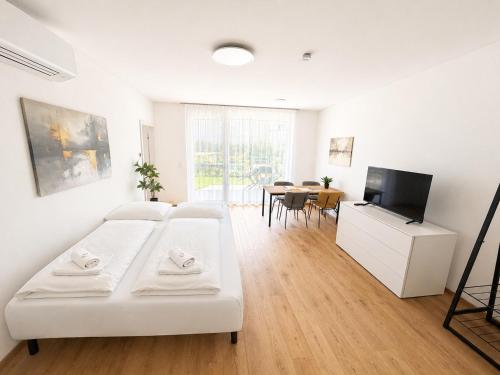 a living room with a white couch and a tv at Am See 18 in Podersdorf am See