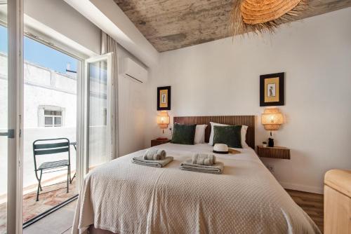 a bedroom with a large bed with towels on it at Casas dos Machados in Tavira