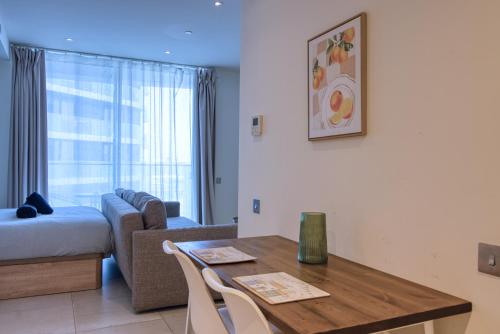 a living room with a table and a couch at New! Luxury Central Complex with Pool Access & Sleeps 4 Ppl in Gibraltar