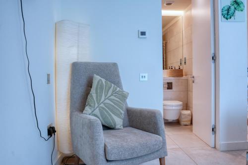 a blue room with a chair with a pillow on it at New! Luxury Central Complex with Pool Access & Sleeps 4 Ppl in Gibraltar