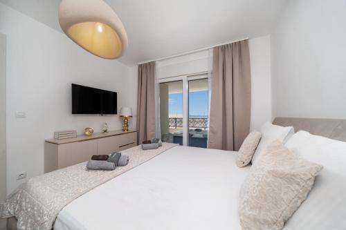 a bedroom with a white bed and a television at Luxury Residence Mauro in Makarska