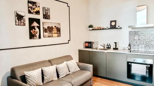 a living room with a couch and a kitchen at Zen Suite - 50m from Metro M1 - Direct to F1 Monza, Fashion Week, Duomo in Milan