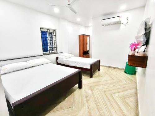 a room with two beds and a window at Sekar Inn in Arumuganeri