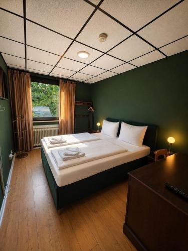 ein Schlafzimmer mit einem großen Bett in einem grünen Zimmer in der Unterkunft Vintage HOTEL S-Weilimdorf in Stuttgart-Weilimdorf