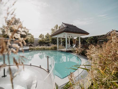 a swimming pool with a gazebo in a yard at Fichtenwald-Ihr Boutique I Glück`s Hotel - Ihr Kraftort - Wasserwelten Bad Füssing in Bad Füssing