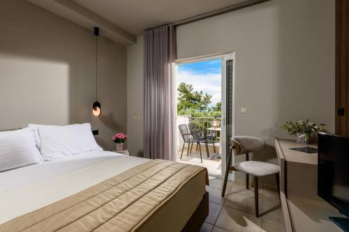 a hotel room with a bed and a balcony at Louloudis Boutique Hotel in Skala Rachoniou
