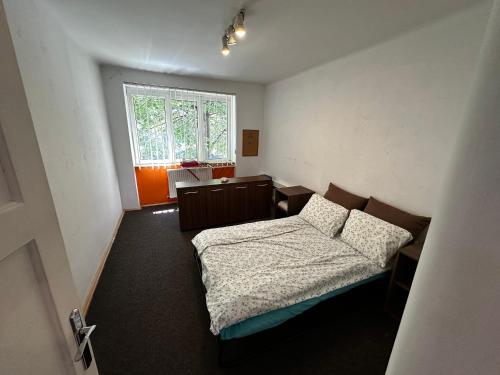 a small bedroom with a bed and a window at LUMON Ultra Central Apartman in Târgu-Mureş