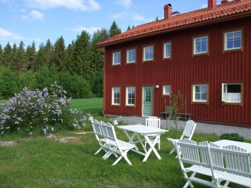 a table and chairs in front of a red house at Allsta Gård Kretsloppshuset B&B in Bjärtrå