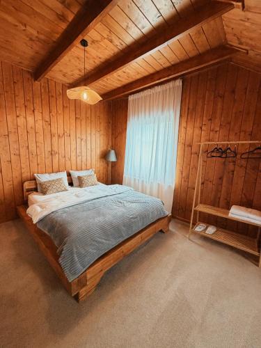 a bedroom with a bed in a wooden room at Sunset Mountains Village in Dealu Negru