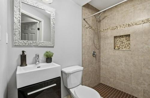 a bathroom with a toilet and a sink and a shower at Cozy Kitchener-Waterloo Home in Kitchener