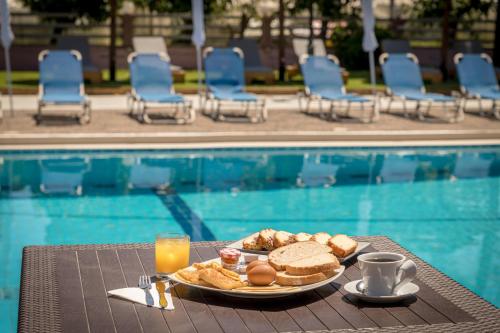 a plate of food on a table next to a pool at Apollo Hotel in Laganas