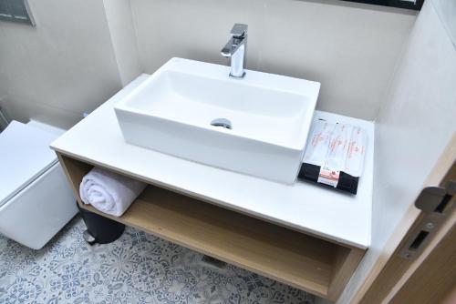 a bathroom with a white sink in a room at Vels Grand Hotel in Kanchipuram