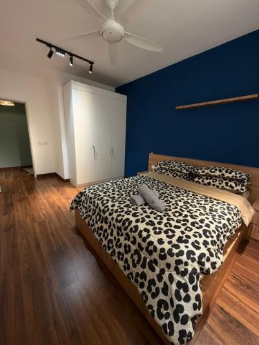 a bedroom with a black and white bed and a blue wall at The Amour Suite in Teluk Panglima Garang