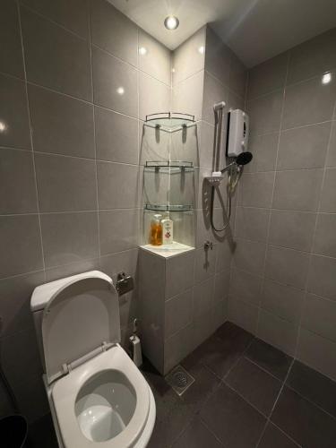 a bathroom with a toilet and a phone on the wall at The Amour Suite in Teluk Panglima Garang