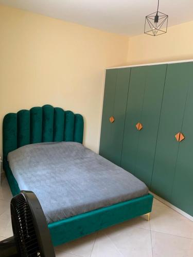 a bed with a green headboard in a room at Beautiful 2-bedroom apartment in Assomada