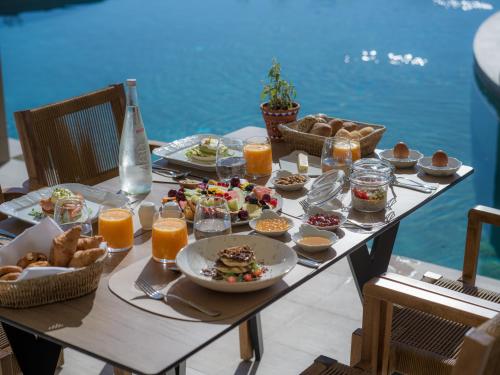 a table with food and drinks on it next to the water at The Landmark Villas & Spa in Kolymbia
