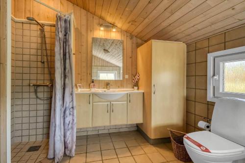 a bathroom with a toilet and a sink and a mirror at C11653-Hemmet-Ranunkelvaenget-4 in Hemmet