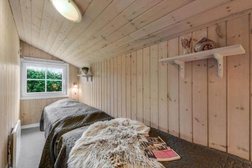 a bedroom with two beds in a room with wooden walls at C11653-Hemmet-Ranunkelvaenget-4 in Hemmet
