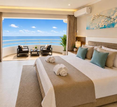 a bedroom with a large bed with a view of the ocean at Luxury Ocean View Apartments I Sunset Terrace I Pool I 200m to Praia dos Três Castelos in Portimão