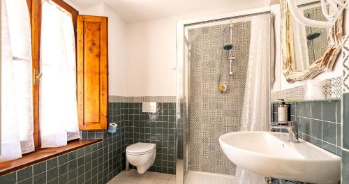 a bathroom with a sink and a toilet and a shower at Locanda Casalta in Strove