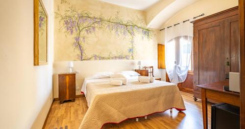 a bedroom with a bed and a painting on the wall at Locanda Casalta in Strove