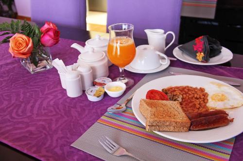a purple table topped with a plate of breakfast food at Salmiya Place in Nairobi