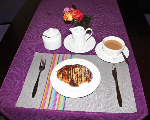 a purple table with a plate of food and a cup of coffee at Salmiya Place in Nairobi