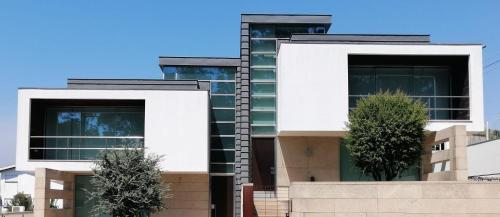 a large white building with two windows at Moradia Lux RR com piscina in Penafiel