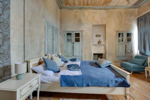 a bedroom with a large bed with blue pillows at Lurji Bani in Sighnaghi