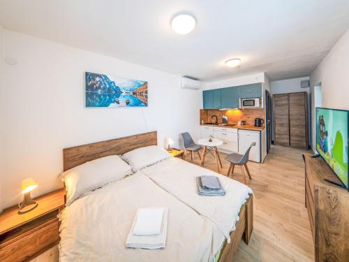 a bedroom with a large bed and a kitchen at Studio V Šachu by Interhome in Dačice