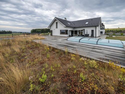 a white house with a wooden deck in a field at Studio V Šachu by Interhome in Dačice