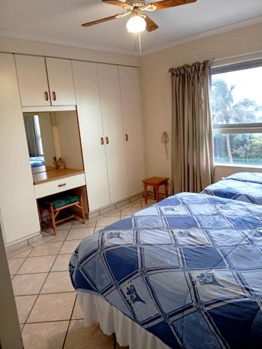 a bedroom with a bed and a desk in it at Beach Retreat in Amanzimtoti