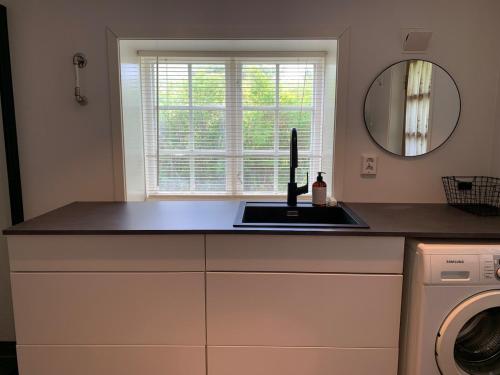 a kitchen counter with a sink and a mirror at Lyngtun in Ørskog