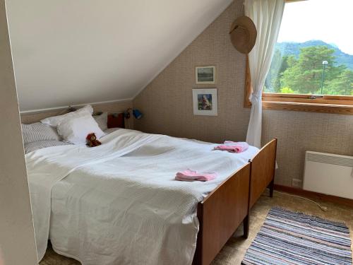 a bedroom with a large bed with pink clothes on it at Lyngtun in Ørskog