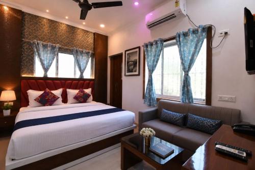 a bedroom with a bed and a couch at Golden Palace in Kolkata