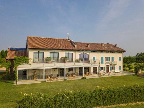 a large white house with a large yard at Braida Wine Resort in Rocchetta Tanaro
