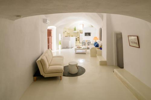 a white living room with a chair and a table at GM Canava1916 in Megalochori