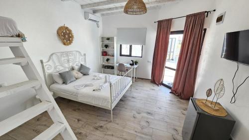 a white room with a bed and a ladder at Thea's Bungalow in Costinesti