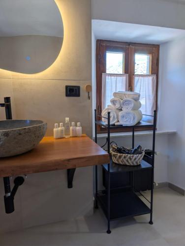 a bathroom with a sink and a shelf with towels at All About You Montefiore in Casola in Lunigiana