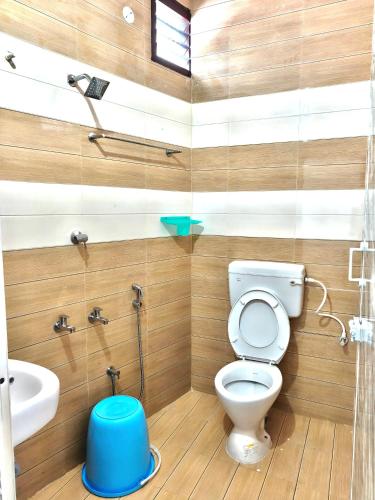 a bathroom with a toilet and a sink at Sekar Inn in Arumuganeri