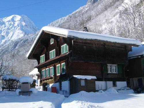 a wooden house in the snow with a mountain at Holiday Home by Interhome in Lungern