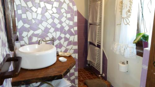 a bathroom with a sink and a mosaic wall at Cascina Bricco in Ovada