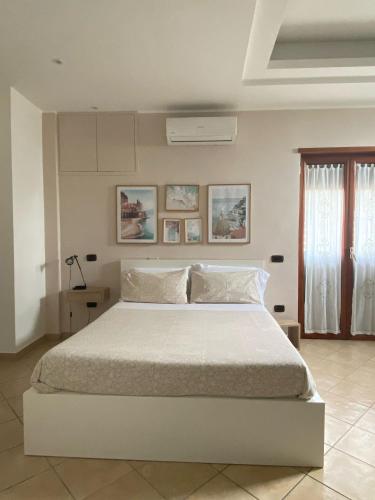 a bedroom with a large white bed in a room at Carla's studio in Pompei