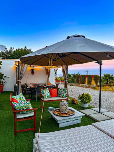 a patio umbrella with a couch and chairs under it at VILLA MADRE in Marina Serra