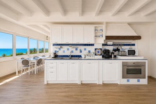 a kitchen with white cabinets and a view of the ocean at B&B TORRE AZUL FRONTEMARE - Bisceglie in Bisceglie