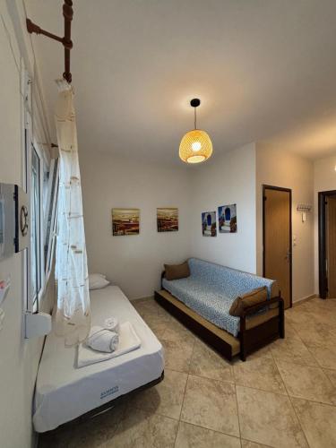 a bedroom with two beds and a pendant light at Val beach apartment in Nea Potidaea