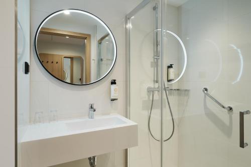 a white bathroom with a sink and a mirror at Première Classe Warsaw Airport in Warsaw