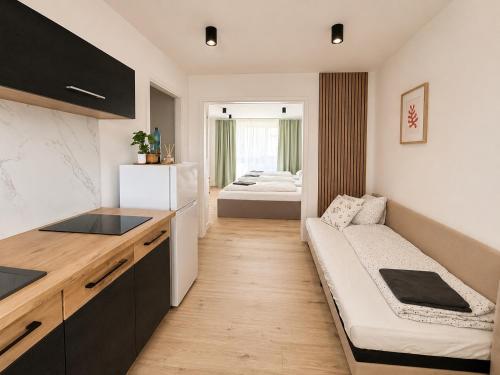 a kitchen with a couch and a bed in a room at Apartmán Strážske s balkónom in Michalovce