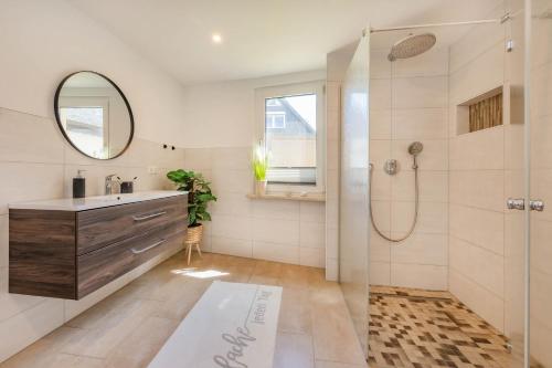 a bathroom with a shower and a sink and a mirror at Ferienhaus Seebrise in Loddin